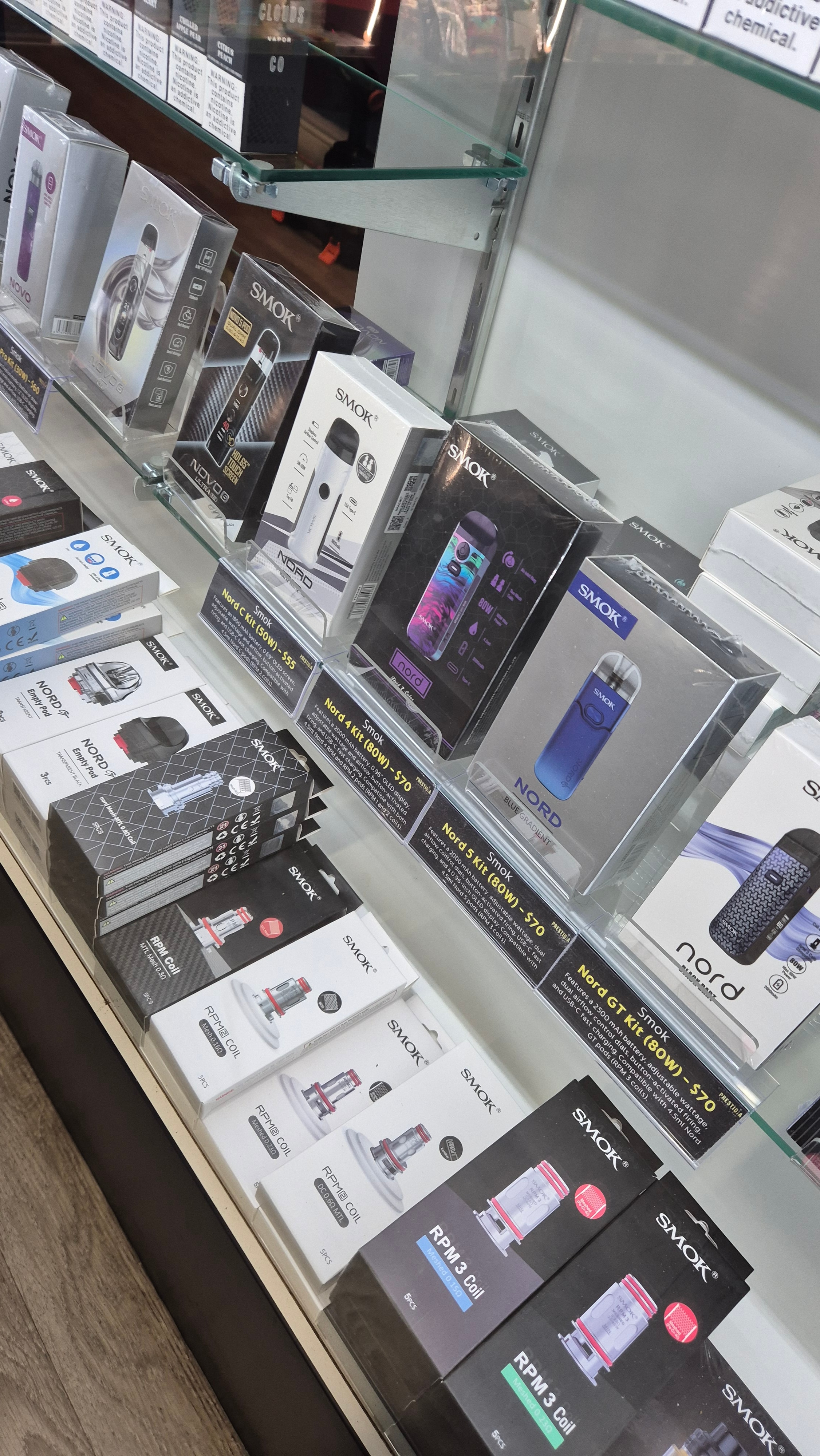 Smok Nord and Novo pod kits in the counter case with RPM replacement coils and pods.